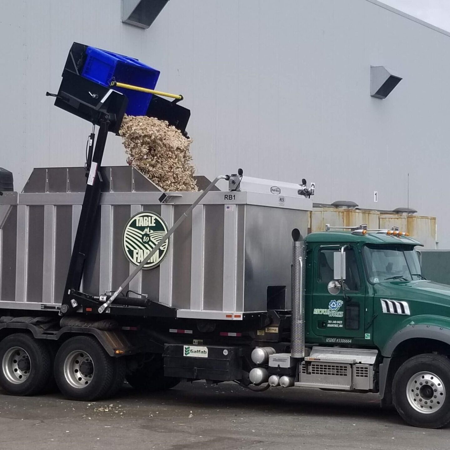 Recycleworks organics truck emptying organic waste from dumpster into truck