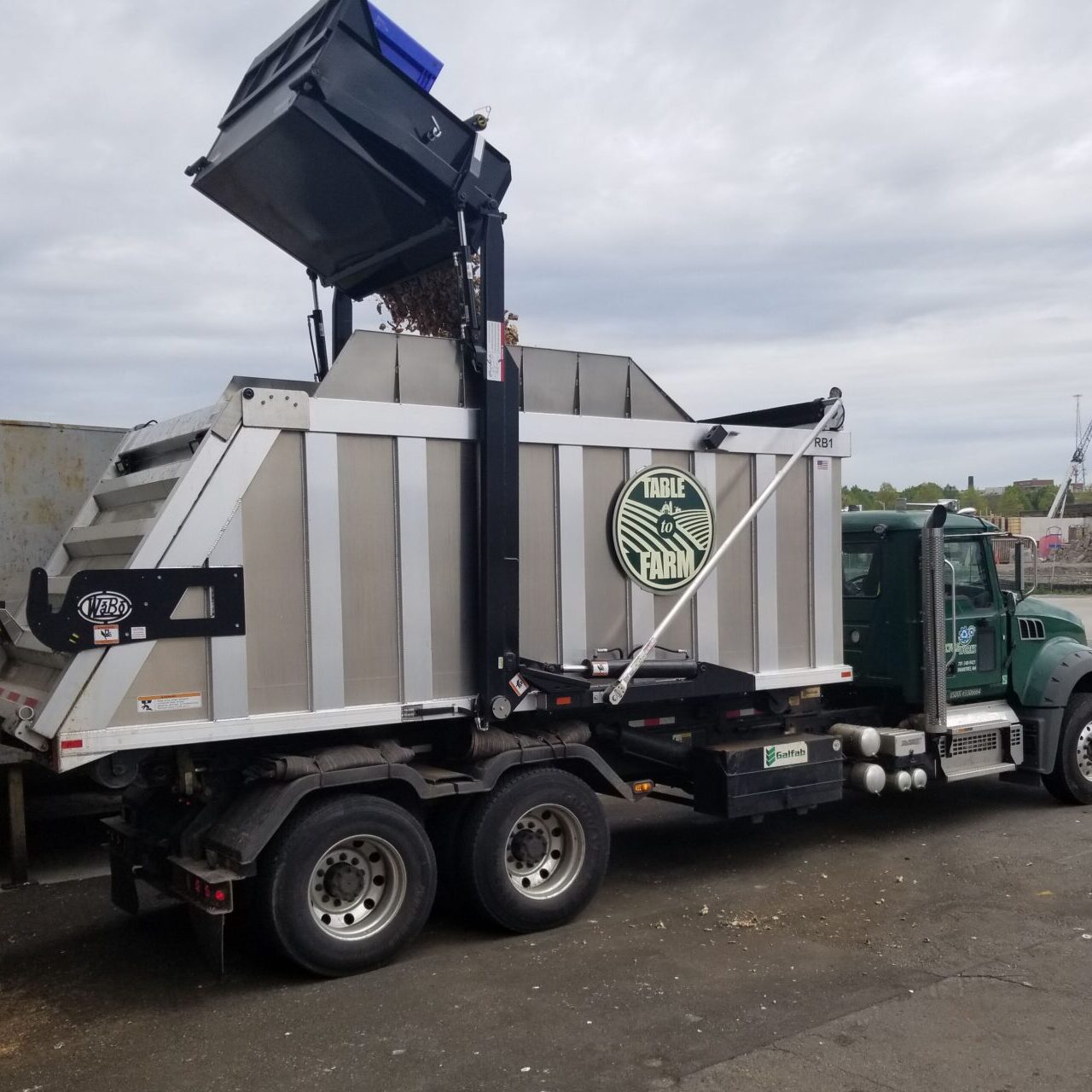 Recycleworks organics truck (Table to Farm) emptying a dumpster